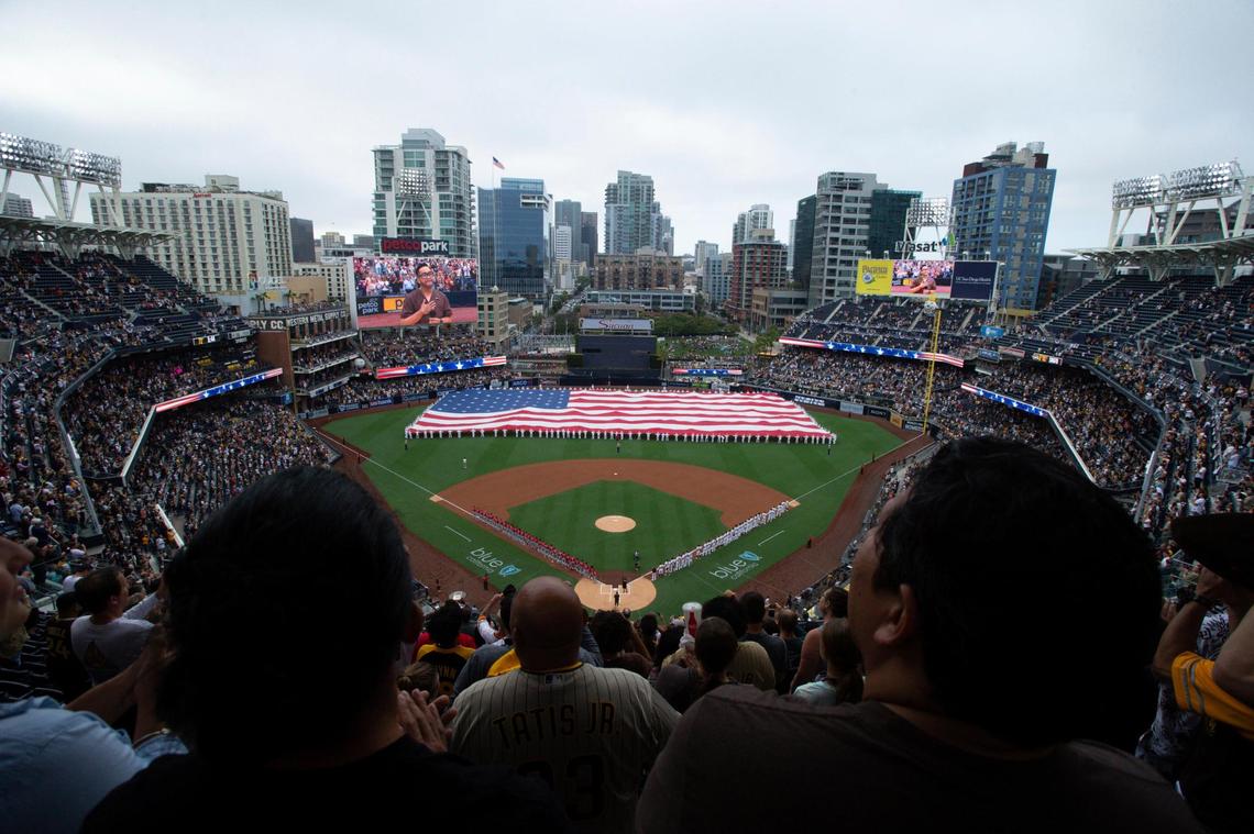 A giant American flag is displayed during the national anthem prior to a baseball game between the San Diego Padres and the Cincinnati Reds Thursday, June 17, 2021, in San Diego. Petco Park opened up for full capacity viewing of a baseball game without masks for the first time since the 2019 season. (AP Photo/Derrick Tuskan)