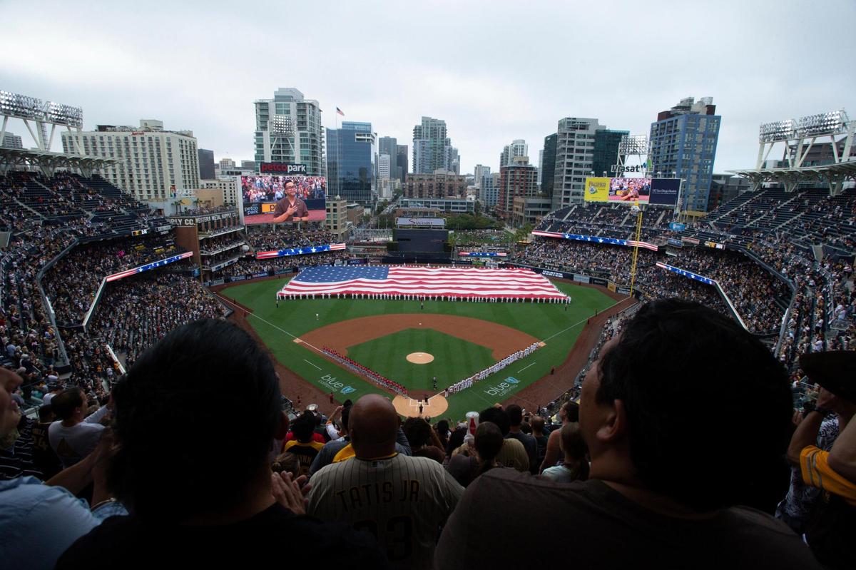 A giant American flag is displayed during the national anthem prior to a baseball game between the San Diego Padres and the Cincinnati Reds Thursday, June 17, 2021, in San Diego. Petco Park opened up for full capacity viewing of a baseball game without masks for the first time since the 2019 season. (AP Photo/Derrick Tuskan)