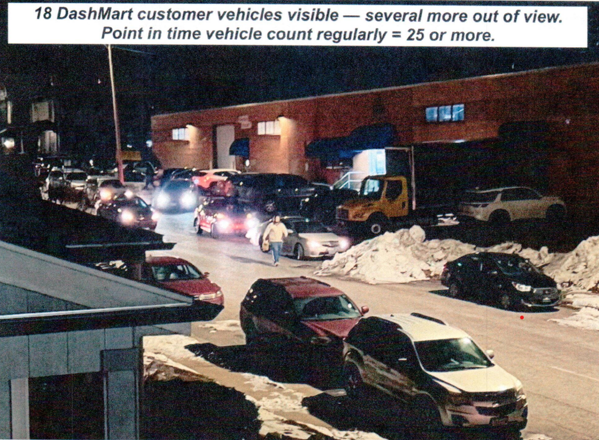 The residential Holmes Street is lined with DoorDash vehicles in this nighttime image, a screenshot of written public testimony on Kansas City’s zoning portal, Compass KC.