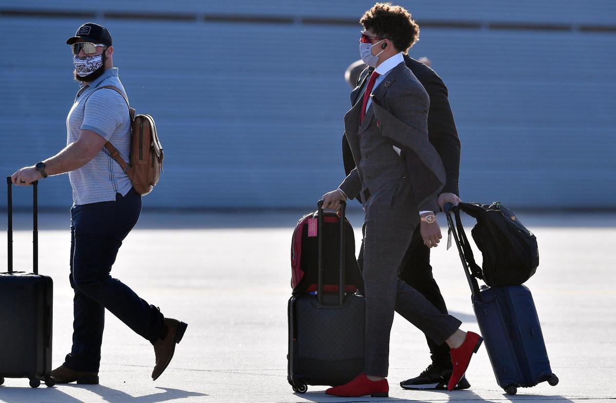 Kansas City Chiefs quarterback Patrick Mahomes, right, follows teammate Anthony Sherman to an awaiting bus after stepping off the team plane Saturday evening upon arrival in Tampa, where they will take on the Tampa Bay Buccaneers in Super Bowl LV on Sunday.