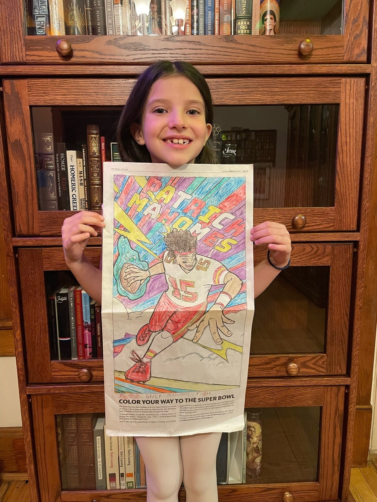 Esmé Hart Guthrie poses with her coloring sheet of Patrick Mahomes, which incorporates this year’s Super Bowl colors into the background. Esmé is a second grader at Academy Lafayette in Kansas City, Missouri.