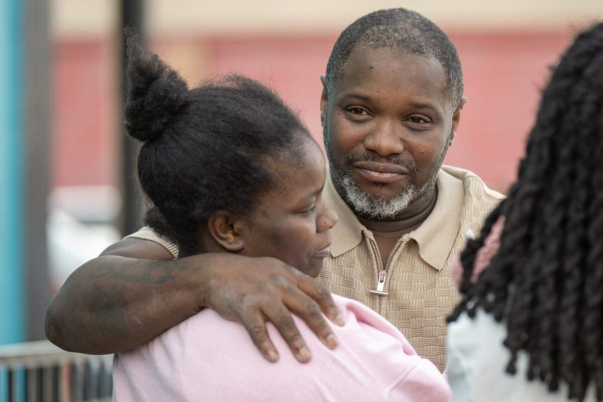 Edward Washington, father of Eboni Silas, is comforted at a memorial balloon release outside the club at 2801 Southwest Blvd. on Monday, Feb. 16, 2026, in Kansas City, one day after a nightclub shooting left two women dead. Authorities identified the victims as Eboni Silas, 29, and Tishauna Ballard, 23.