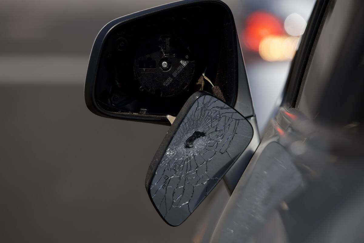 A car mirror appears to have been shot while parked at 19th and Vine streets on Saturday, June 20. Police said several people were injured and one man was killed in a shooting in the area the night before.