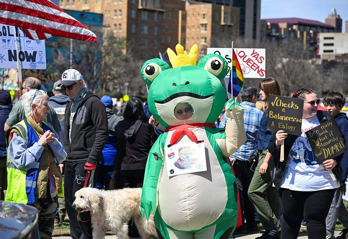 A protester wears a frog costume at a No Kings rally against the Trump administration in Mill Creek Park near the Country Club Plaza on Saturday, March 28, 2026, in Kansas City.