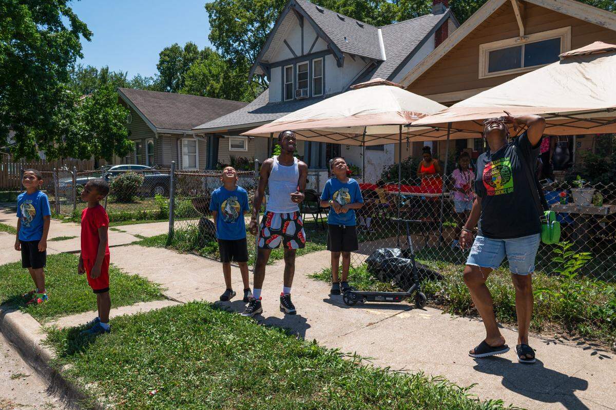 Oak Park Northwest residents look into the sky after lighting off a bottle rocket on Tuesday, July 4, 2023, in Kansas City. The neighborhood celebrated the holiday with block parties, barbecues, and fireworks.