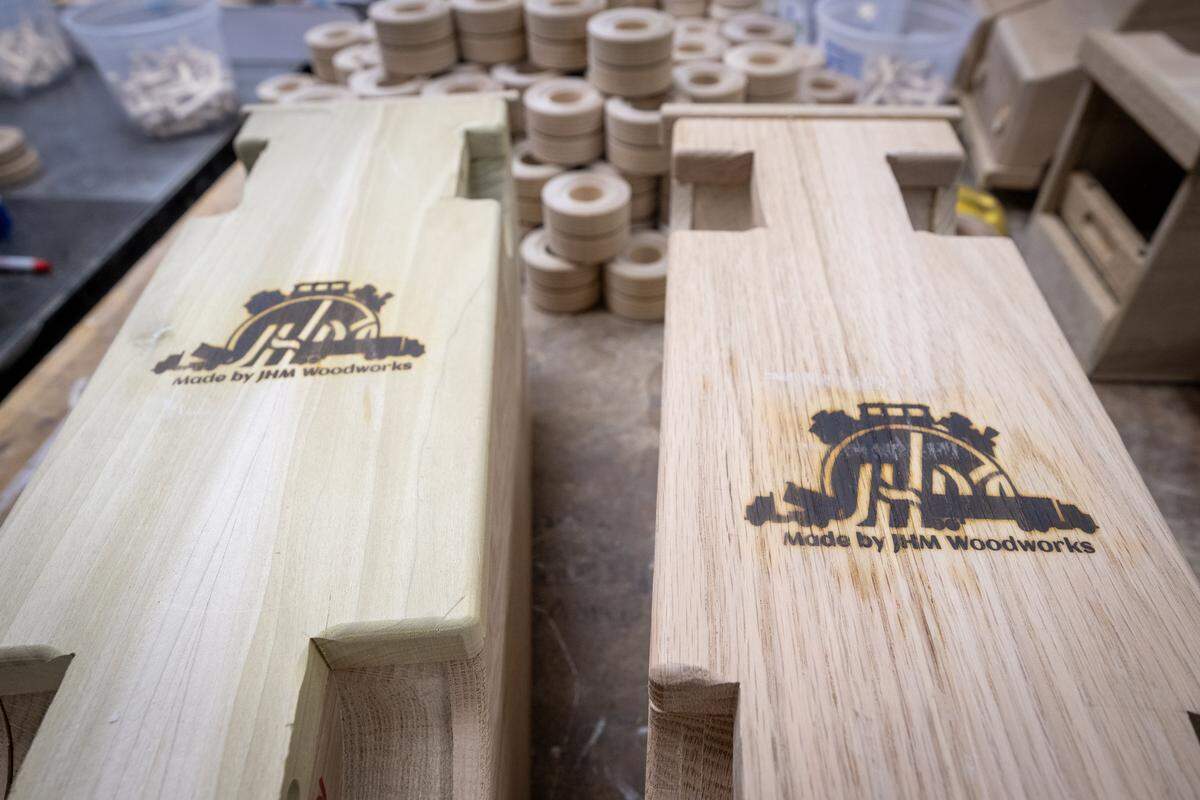The underside of the handmade trucks are stamped by Jay Morris of JHM Woodworks as seen on Tuesday, Dec. 2, 2025 in Lawrence, Kansas.The 115 handmade trucks will be donated to Toys for Tots.