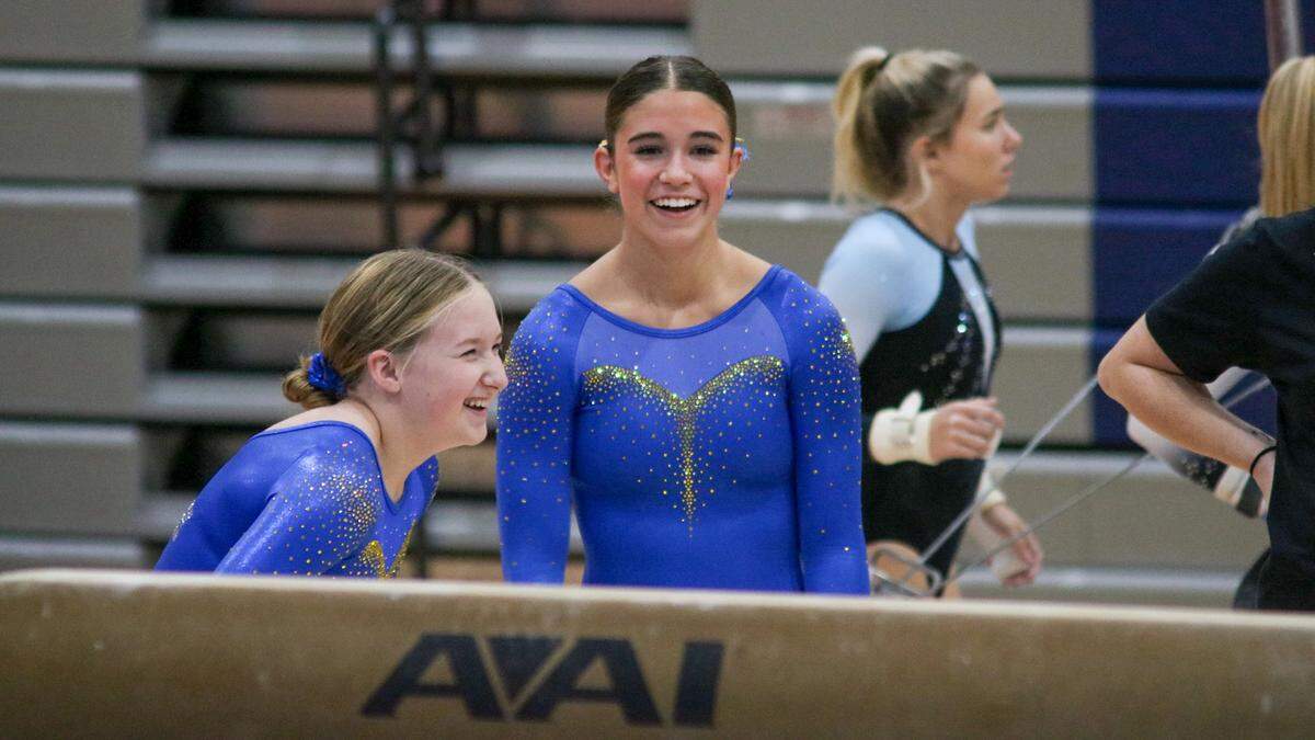Keira Spence, middle, a 17-year-old senior at Olathe South High School laughs with a teammate at the 2025 state meet.