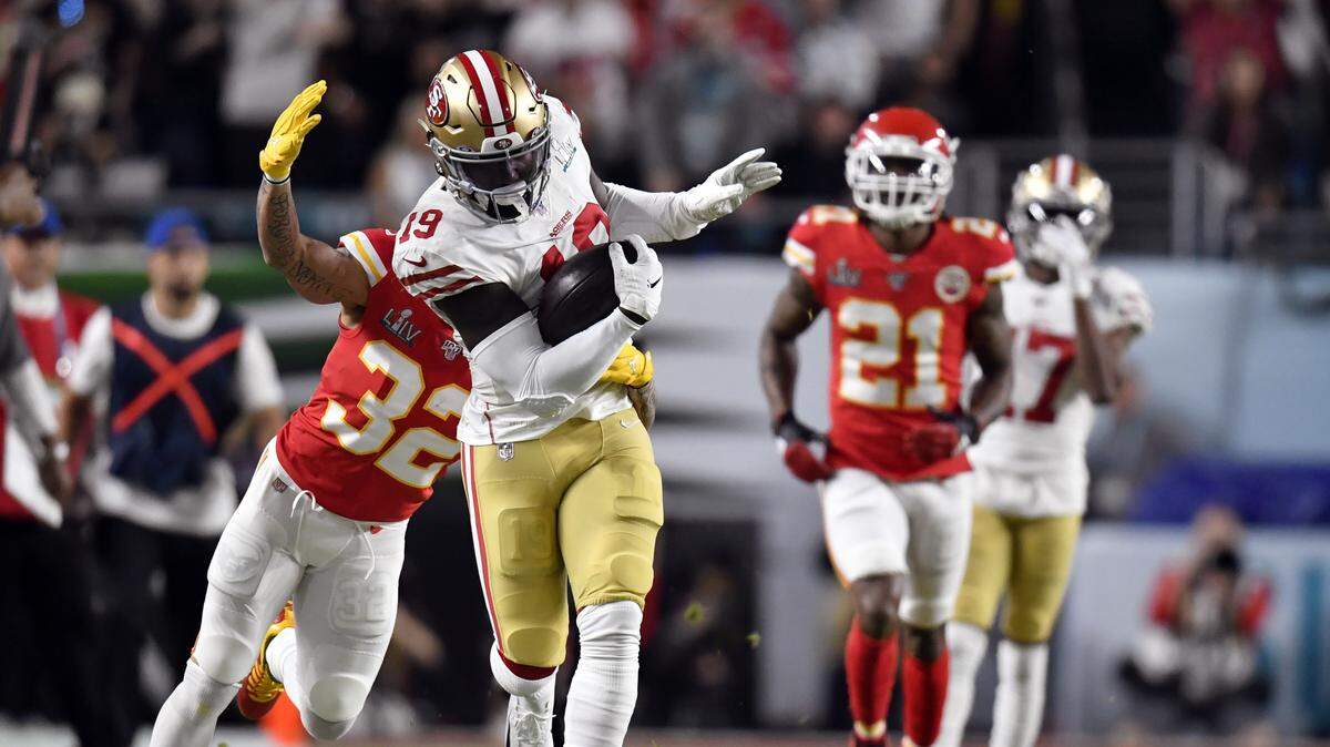 San Francisco 49ers receiver Deebo Samuel (No. 19) catches a pass over Chiefs safety Tyrann Mathieu during the first half of Super Bowl LIV at Miami in February 2020.