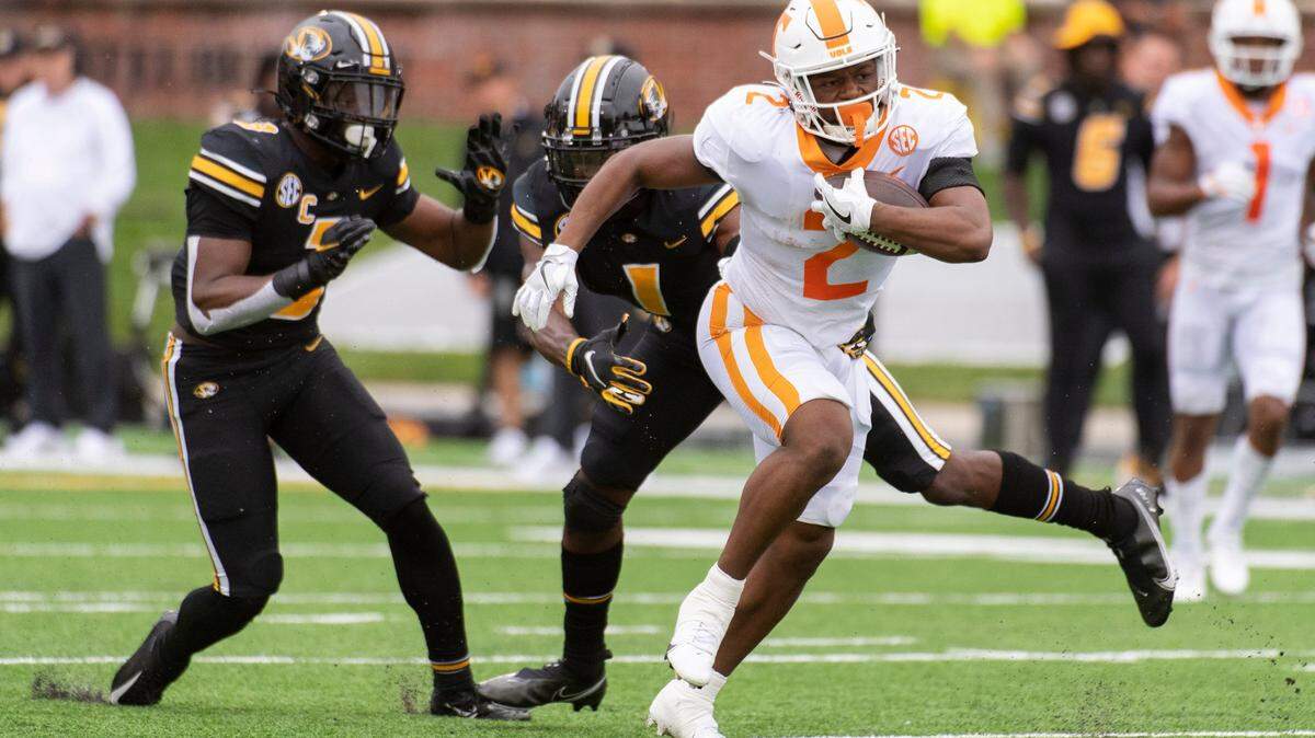 Tennessee running back Jabari Small, right, runs past Missouri’s Jaylon Carlies, center, and Martez Manuel during the first half of an NCAA college football game Saturday, Oct. 2, 2021, in Columbia, Mo. (AP Photo/L.G. Patterson)