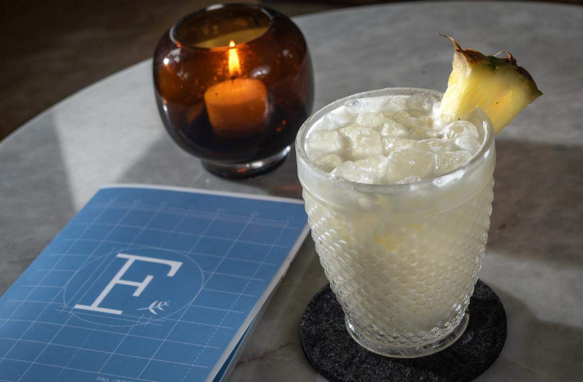 Diana Condori, a bartender at Fern Bar, prepared a Piña Colada on Thursday, March 5, 2026. The cocktail features a house rum blend, Clément Coconut, coconut cream, pineapple, and lime. Condori is a 2026 James Beard Award nominee for Outstanding Professional in Cocktail Service.