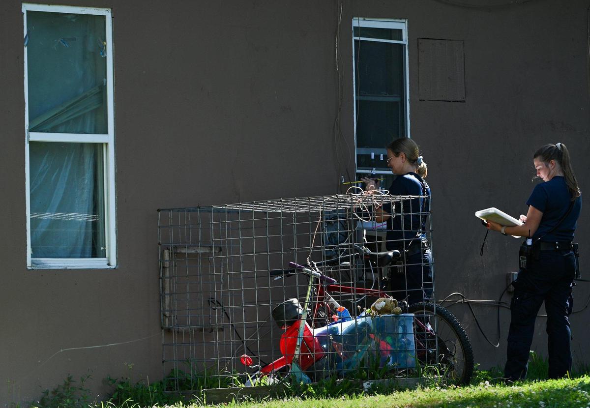Crime scene personnel and Kansas City police investigate the site of an early morning homicide Monday in the 2600 block of Cypress Avenue.