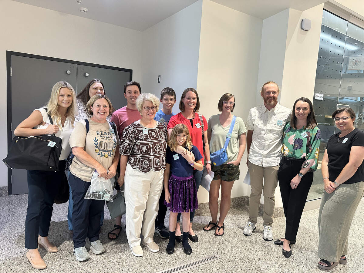 A few community members with “School Beyond Screens” pins pose for a photo outside the Shawnee Mission Board of Education meeting on June 22. The School Beyond Screens chapter is the first to be formed in the state of Kansas.