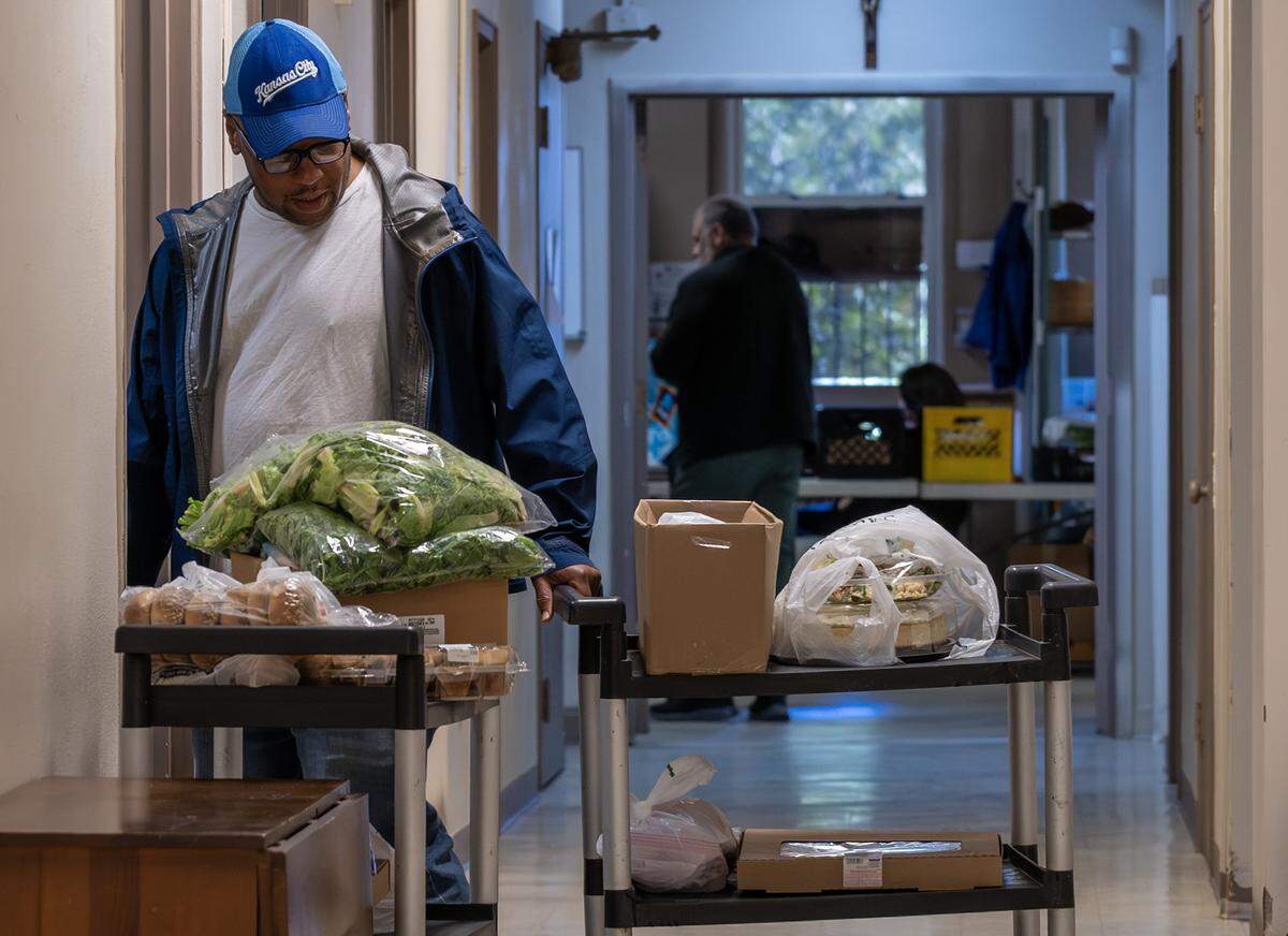 A client wheels a cart filled with food at the Redemptorist Center food pantry on Monday, Nov. 3, 2025, in Kansas City. Food pantries across the region are struggling to meet demand as many families face reduced or frozen SNAP benefits.