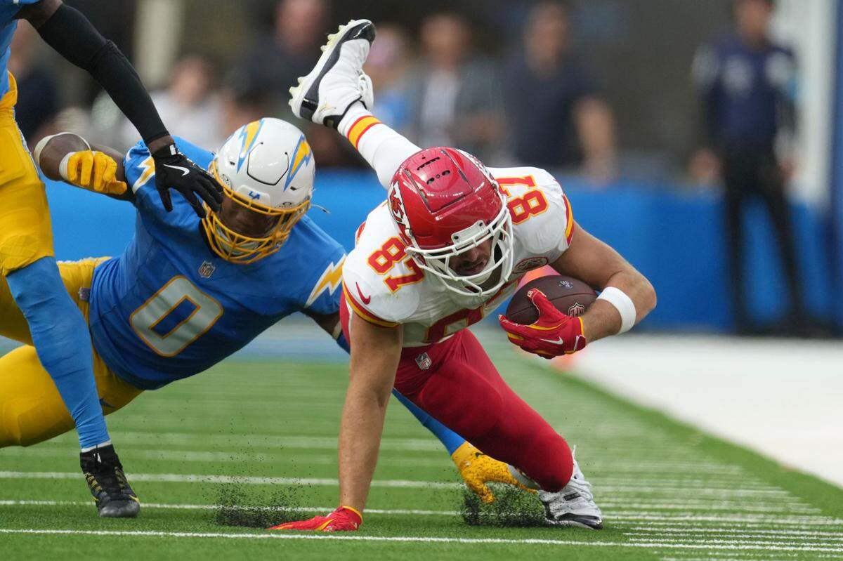 Kansas City Chiefs tight end Travis Kelce (87) runs against Los Angeles Chargers linebacker Daiyan Henley (0) in the second half at SoFi Stadium.