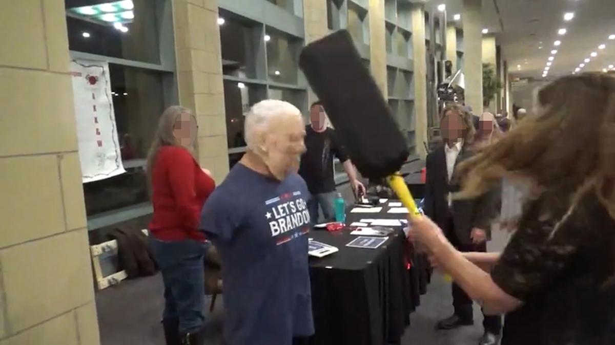 An unidentified woman hits an effigy of President Joe Biden at the Johnson County Republican Party's "A Grand Ol' Party" March 8, 2024