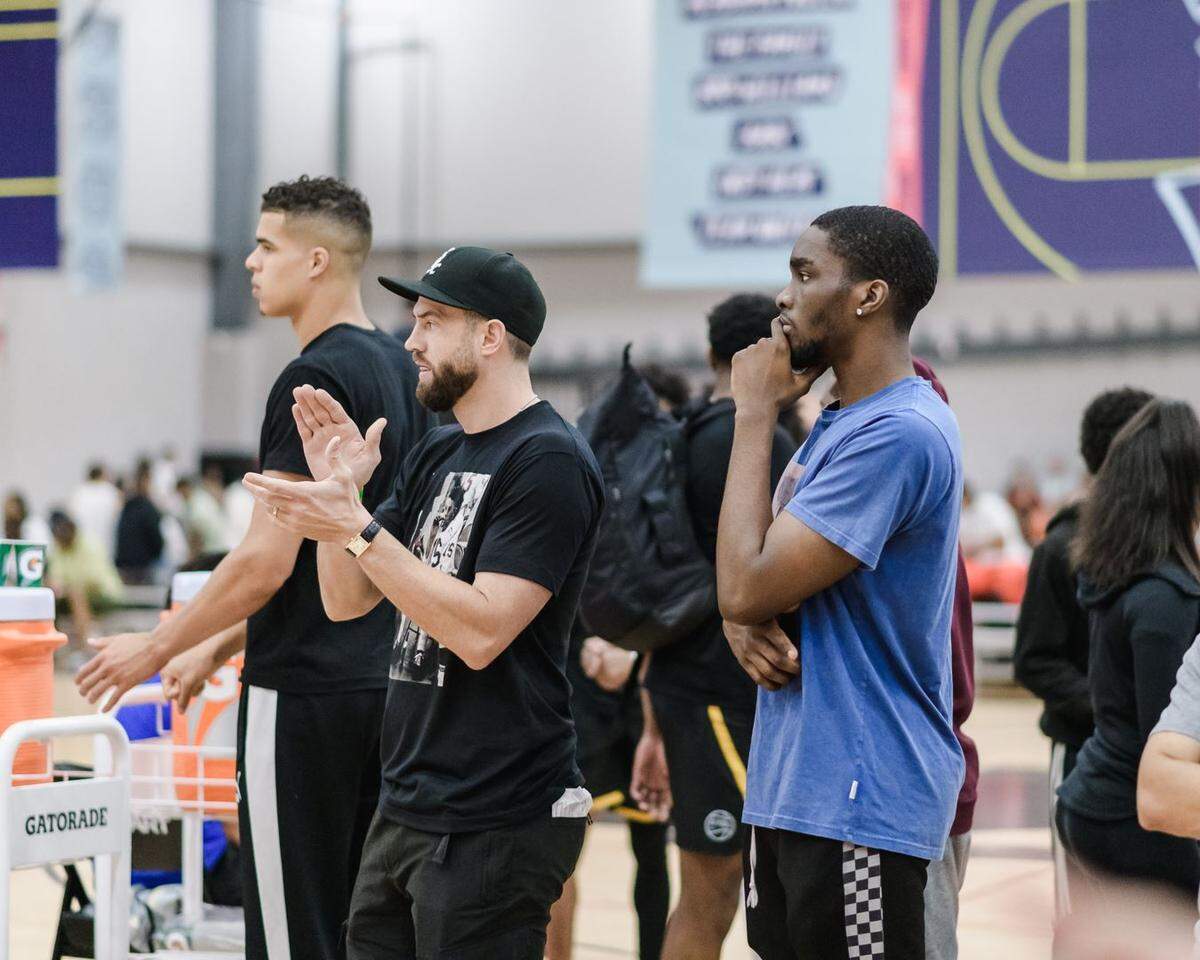 From left, Michael Porter Jr., program director Matt Suther and Shake Milton watch Mokan play at a Nike EYBL event.