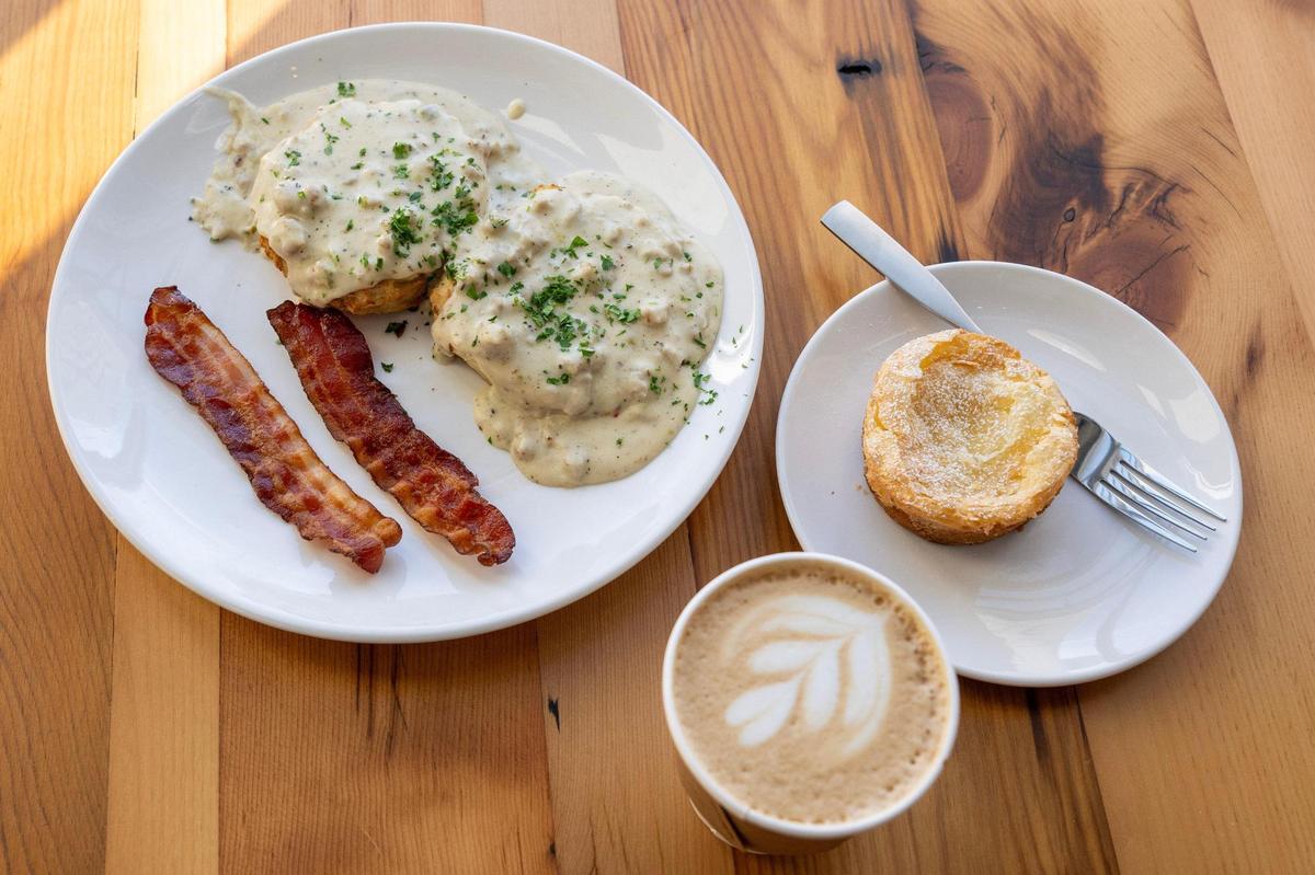 Biscuits and sausage gravy are served with bacon, a pastry, and a latte, at Mildred’s on Thursday, Jan. 9, in Kansas City.