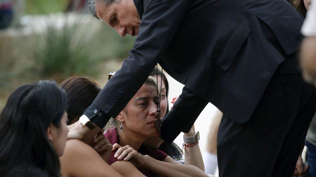 El arzobispo de San Antonio, Gustavo García Seller, consuela a las familias afuera del Centro Cívico tras el mortal tiroteo en Robb Elementary School, en Uvalde, Texas, el martes 24 de mayo de 2022.