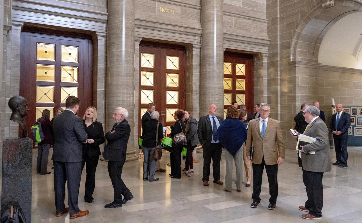 Lobbyists meet with state representatives outside of the House chamber on Tuesday, March 7, 2023, at the state Capitol in Jefferson City, Mo.