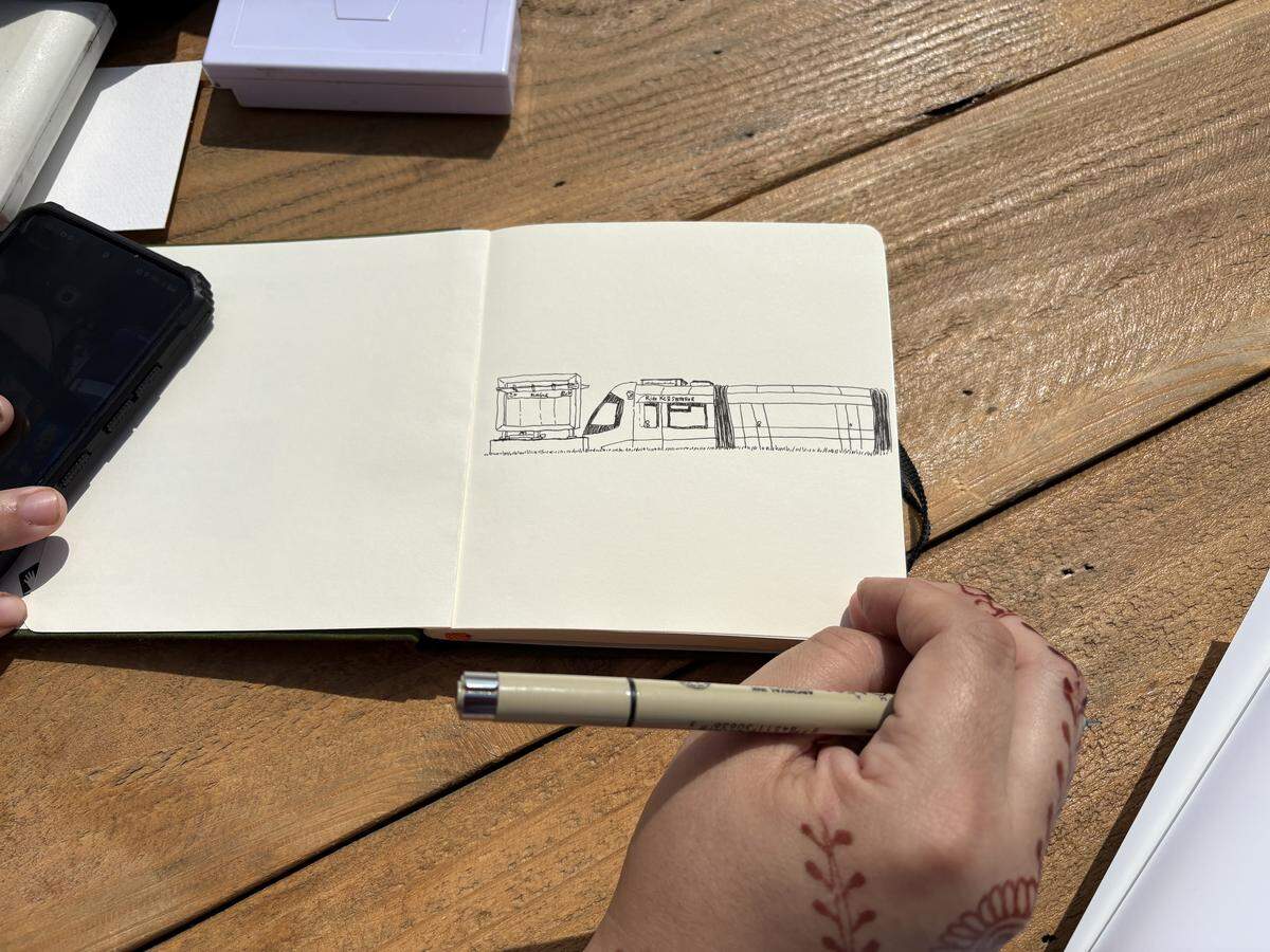 Laura Clark, of Downtown Kansas City, draws the Kansas City streetcar at the grand opening of the Riverfront streetcar extension. May 18, 2026.
