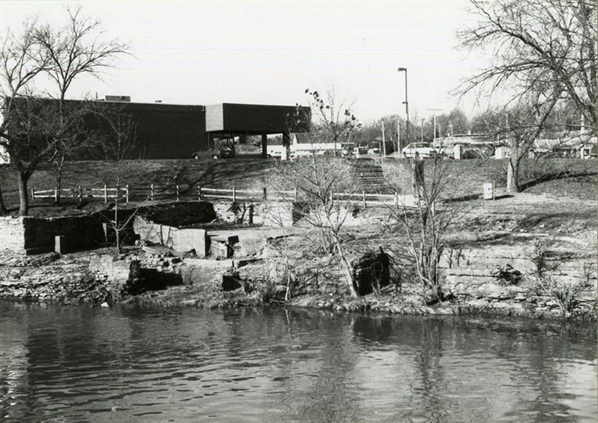 Watts Mill ruins, with the Watts Mill shopping center in the background. From “Notes on Fitzhugh’s/Watts’ Mill” by Ronald Becher, 1992.