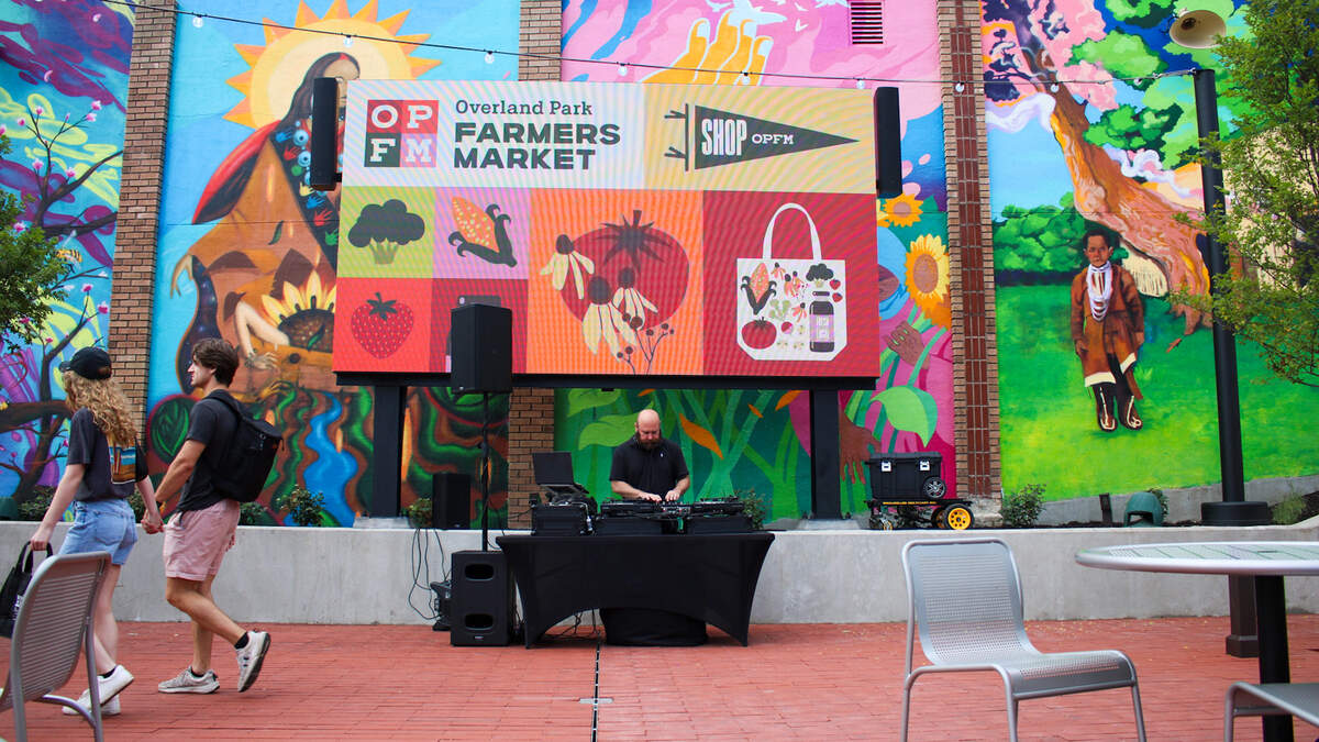 A DJ plays music at the Overland Park Farmer’s Market Clock Tower Landing on June 6, 2026.