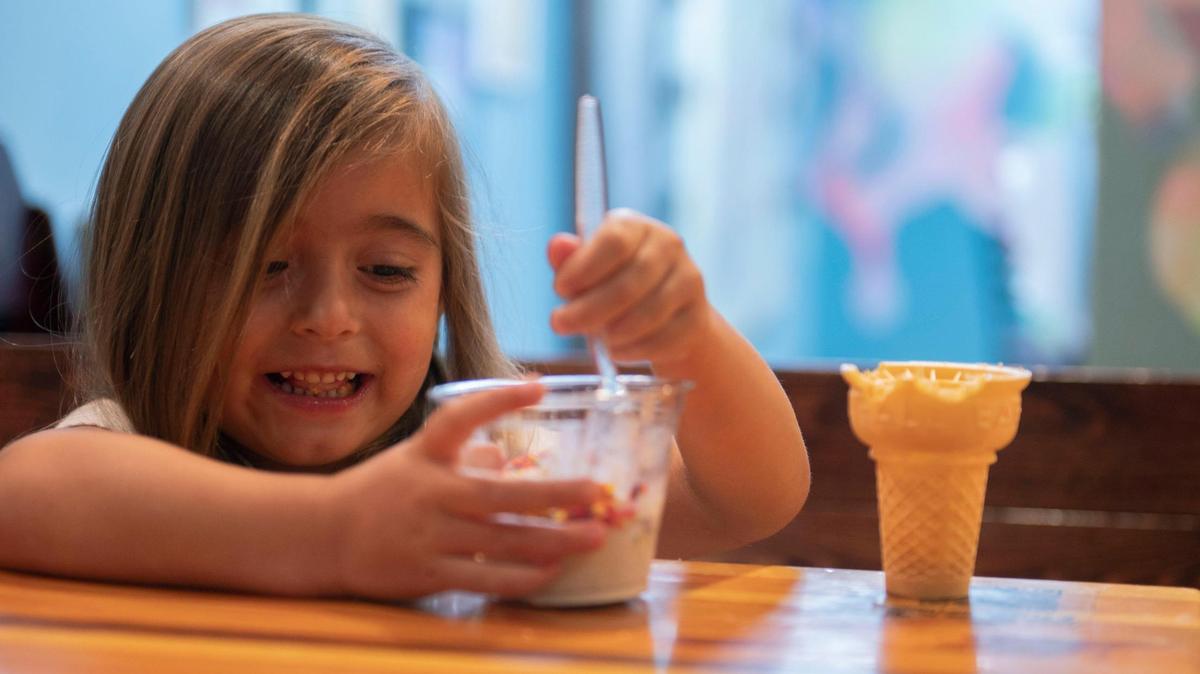 Three-year-old Ellie Paluka eats a scoop of ice cream with sprinkles and a cone on the side from Betty Rae’s in Waldo during a hot summer day in Kansas City in July 2022.