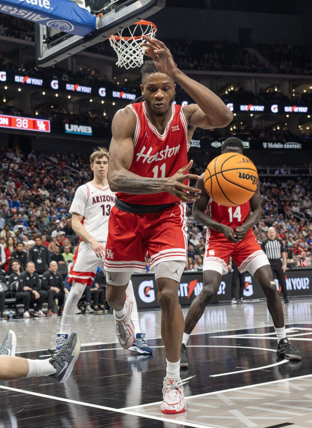 Houston Cougars forward Joseph Tugler (11) attempts to save the ball from going out of play during the second half of the Big 12 Men's Basketball Tournament Championship game against the Arizona Wildcats at T-Mobile Center on Saturday, March 14, 2026, in Kansas City.