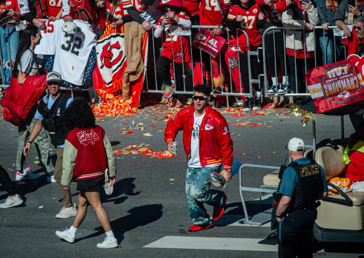 Kansas City Chiefs quarterback Patrick Mahomes runs with a beer and the Lombardi trophy in his hands to greet fans during the Kansas City Chiefs Super Bowl LVIII victory parade Wednesday, Feb. 14, 2024, in Kansas City.