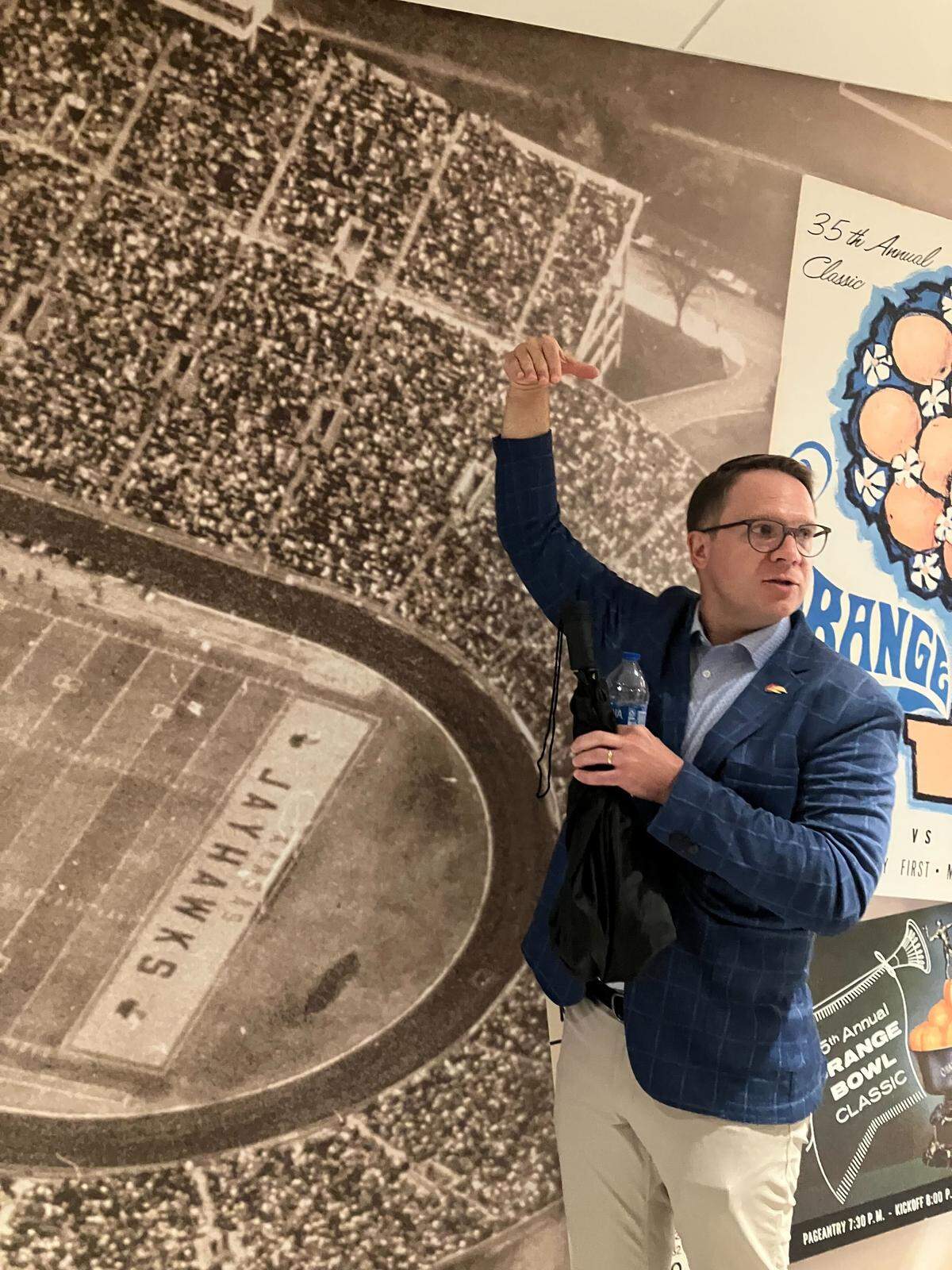 Kansas athletic director Travis Goff talks about the early days of Memorial Stadium while in front of a photo of a Kansas football game played at the old stadium that covers a wall on the suite level in a renovated portion of David Booth Kansas Memorial Stadium.