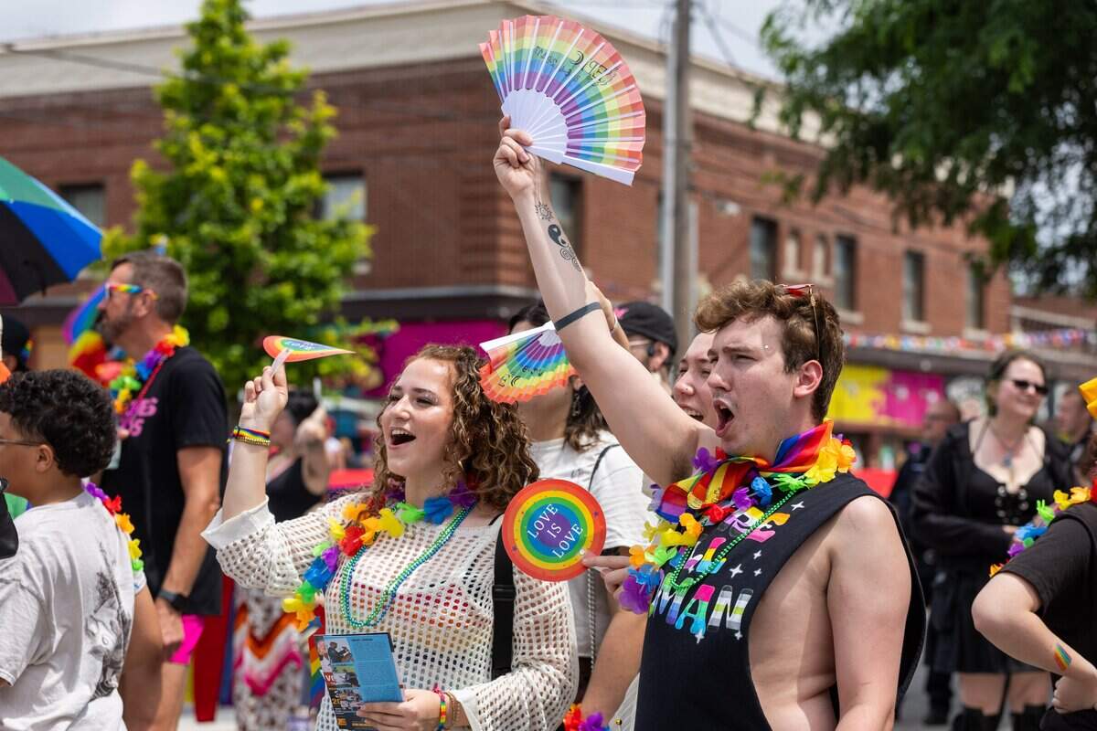 Olivia Hohensinner, 19, left, and Isaiah Keepers, 21 cheer and wave pride fans during Kansas City's Annual Pride Parade at Westport Rd on Saturday, June 6, 2026.