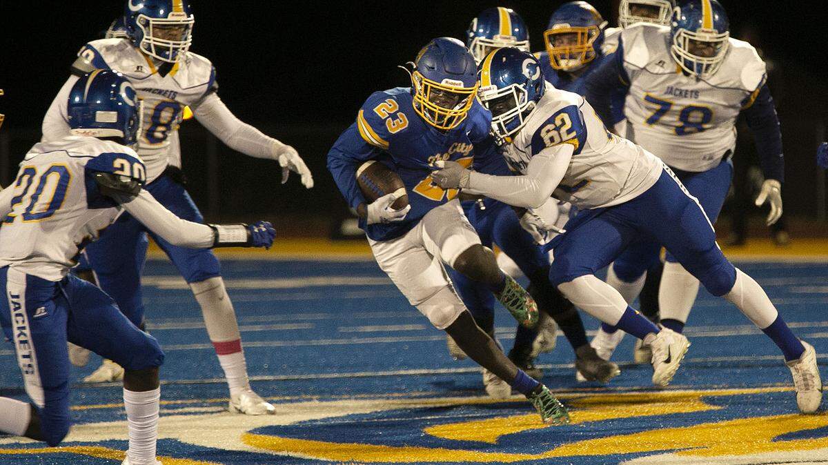 John Price of Lincoln Prep tries to get past the Center High defense during Friday night’s high school football game at Lincoln Prep.