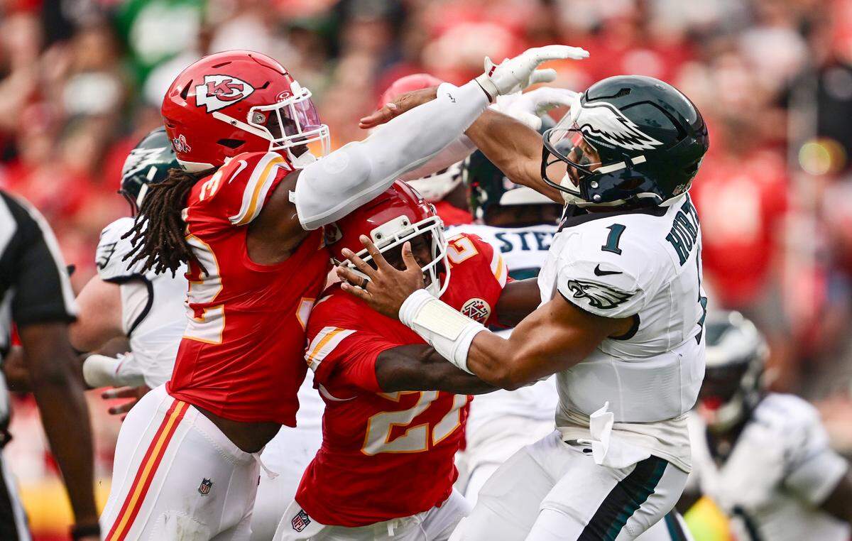 Kansas City Chiefs linebacker Nick Bolton (32) and safety Chamarri Conner (27) pressure Philadelphia Eagles quarterback Jalen Hurts (1) in the third quarter on Sunday, Sept. 14, 2025, at GEHA Field at Arrowhead Stadium.