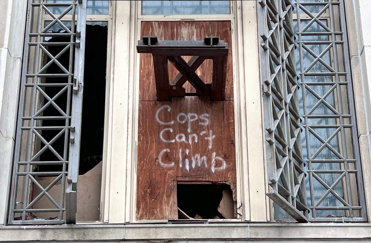 The once-proud façade of 925 Grand is now marked by shattered glass and plywood, as pigeons roost inside the abandoned Federal Reserve building, adding to its deepening decay.