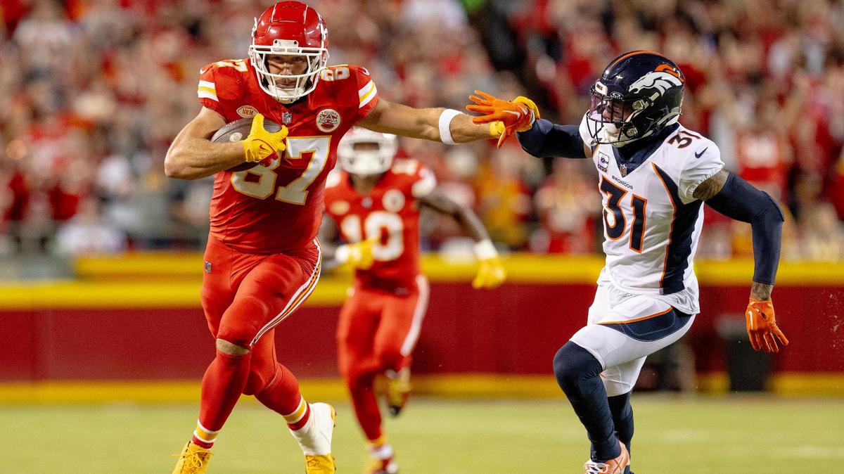 Kansas City Chiefs tight end Travis Kelce (87) runs with he ball and stiff arms Denver Broncos safety Justin Simmons (31) during an NFL football game at GEHA Field at Arrowhead Stadium on Thursday, Oct. 12, 2023, in Kansas City.