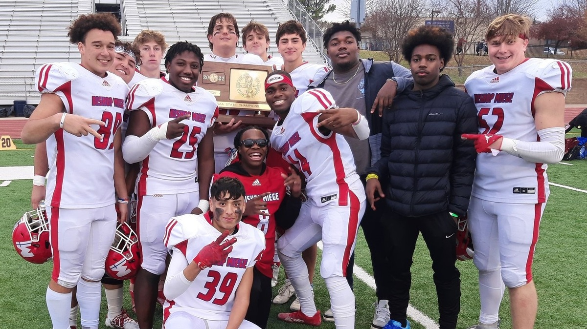 Members of the Bishop Miege football team pose with the Kansas Class 4A state championship football trophy after the team’s win over Wamego on Saturday in Topeka.