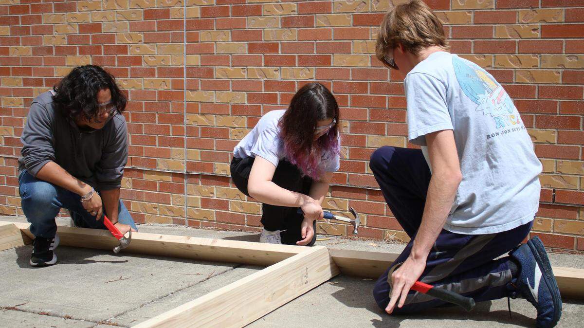 Olathe North sophomores Jordan Chenoweth, Desra Lusby and Matthew Ulrey work together on the tiny home project for their Geometry in Construction class.