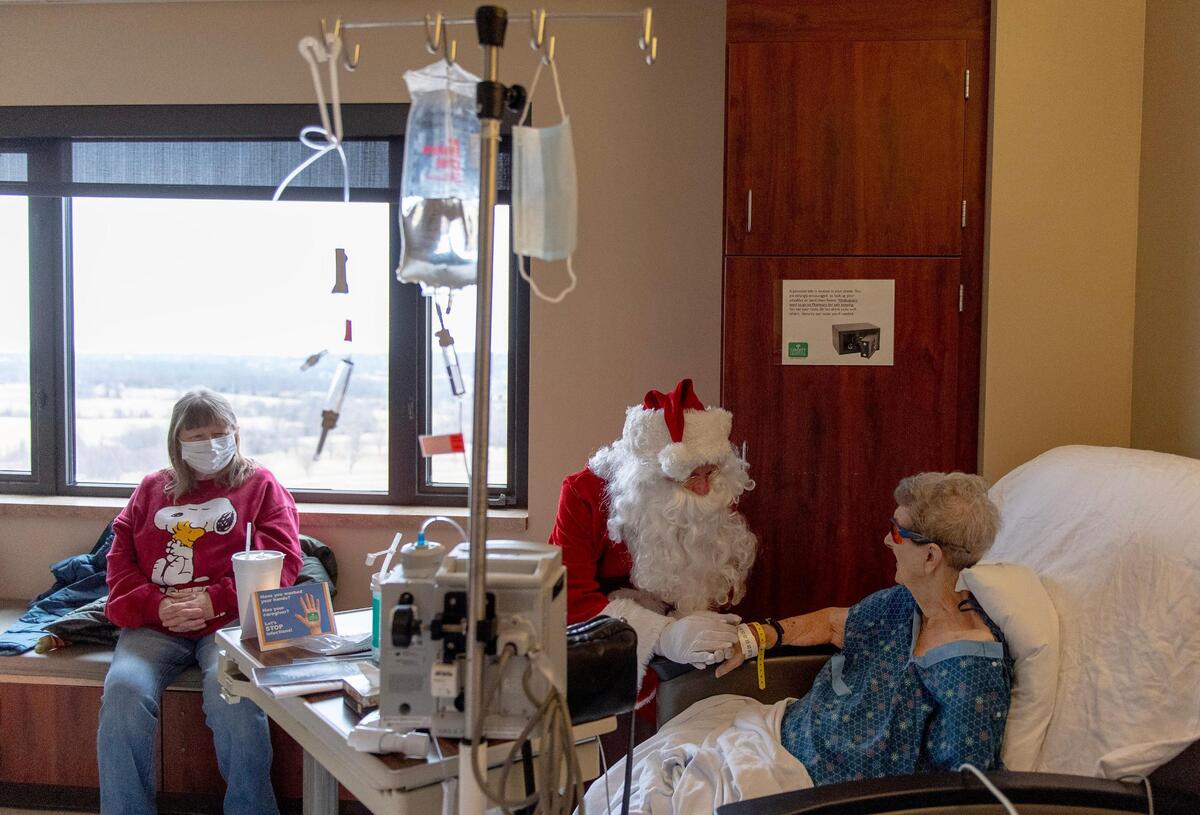 Liberty Hospital employee Rob Kinnard, as Santa Claus, visited patients a few days before Christmas. Here he comforted Deanna Potts, who had fallen in her apartment.