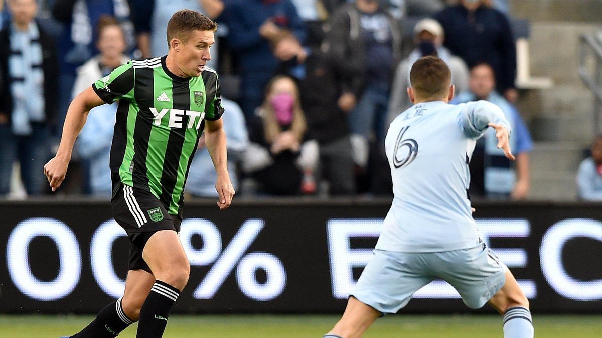 Austin defender and KC native Matt Besler (left) moves the ball against Sporting Kansas City midfielder Ilie Sanchez during Sunday night’s match at Children’s Mercy Park.