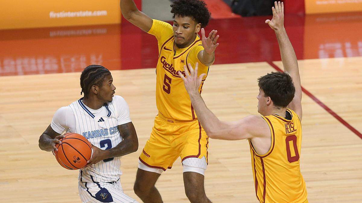 Kansas City Roos’ guard Babacar Diallo looks to pass while being defended by Iowa State’s Curtis Jones (5) and guard Nate Heise (0) in the second half of a NCAA men’s basketball game at Hilton Coliseum on Nov. 11, 2024, in Ames, Iowa.