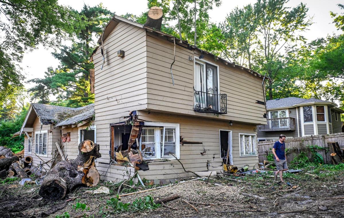 A neighbor looks over a house in the Westwood Park neighborhood that will soon be torn down. Carol Dille had owned it and the house next door, both homes infested with rats, neighbors said. She is now in prison for wire and bankruptcy fraud, and the houses sold for $250,00 each. The second house will be refurbished.