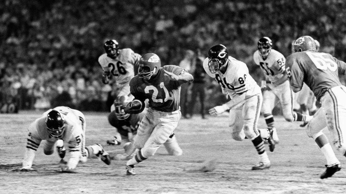Kansas City Chiefs running back Mike Garrett (21) carries the ball pursued by Chicago bears defensive players Dick Butkus (51) and Loyd Phillips (86) at Municipal Stadium during the 1967 preseason.