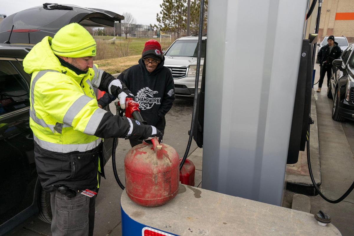 Michael Baxter, the gas supervisor, assists Jan Johnson of Kansas City, when she stopped by the Costco gas station in midtown to fill containers with gas for her generator as she prepared for the approaching winter storm on Saturday, Jan. 4, 2024.