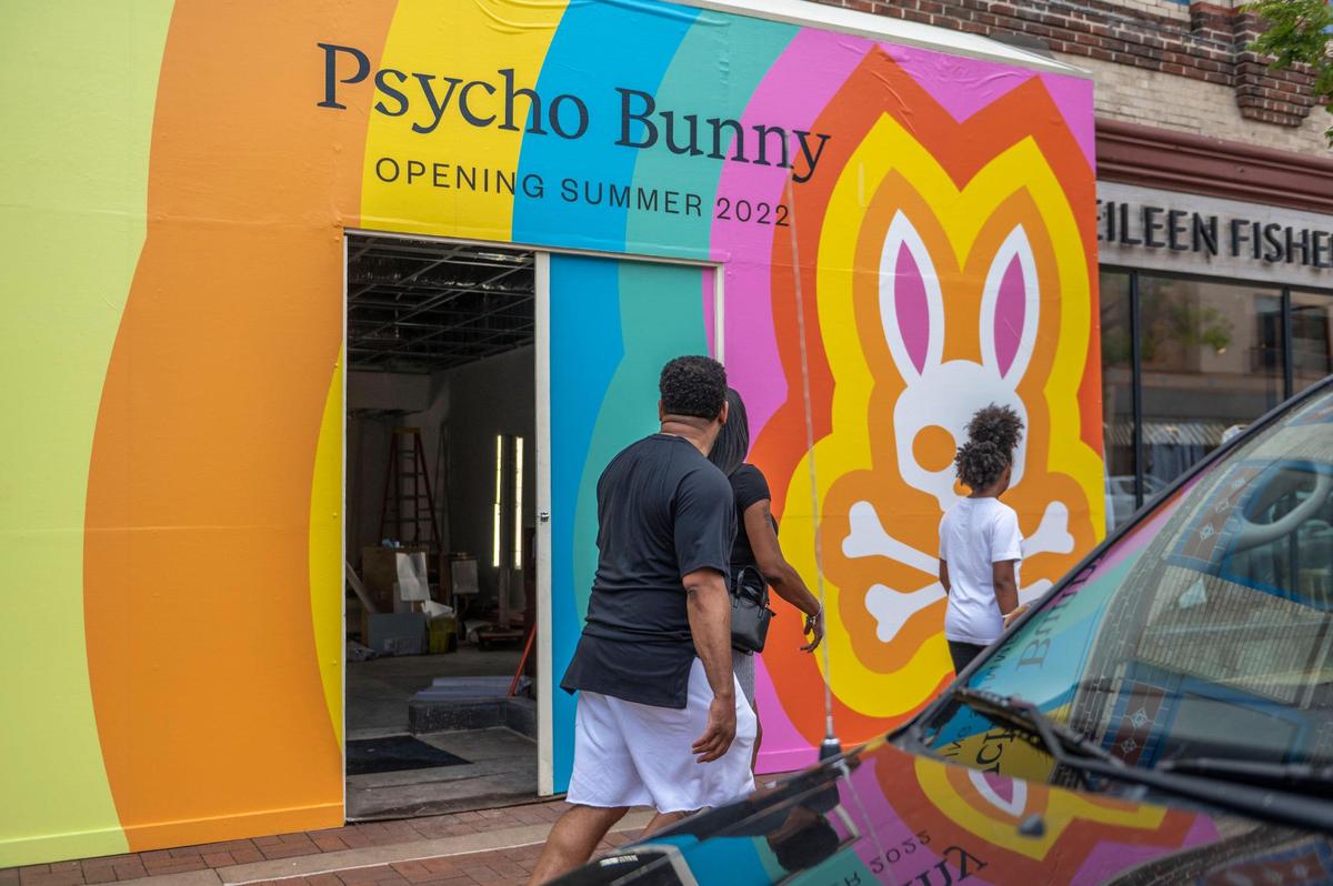 People walk pass Psycho Bunny, which plans a summer opening on the Plaza.