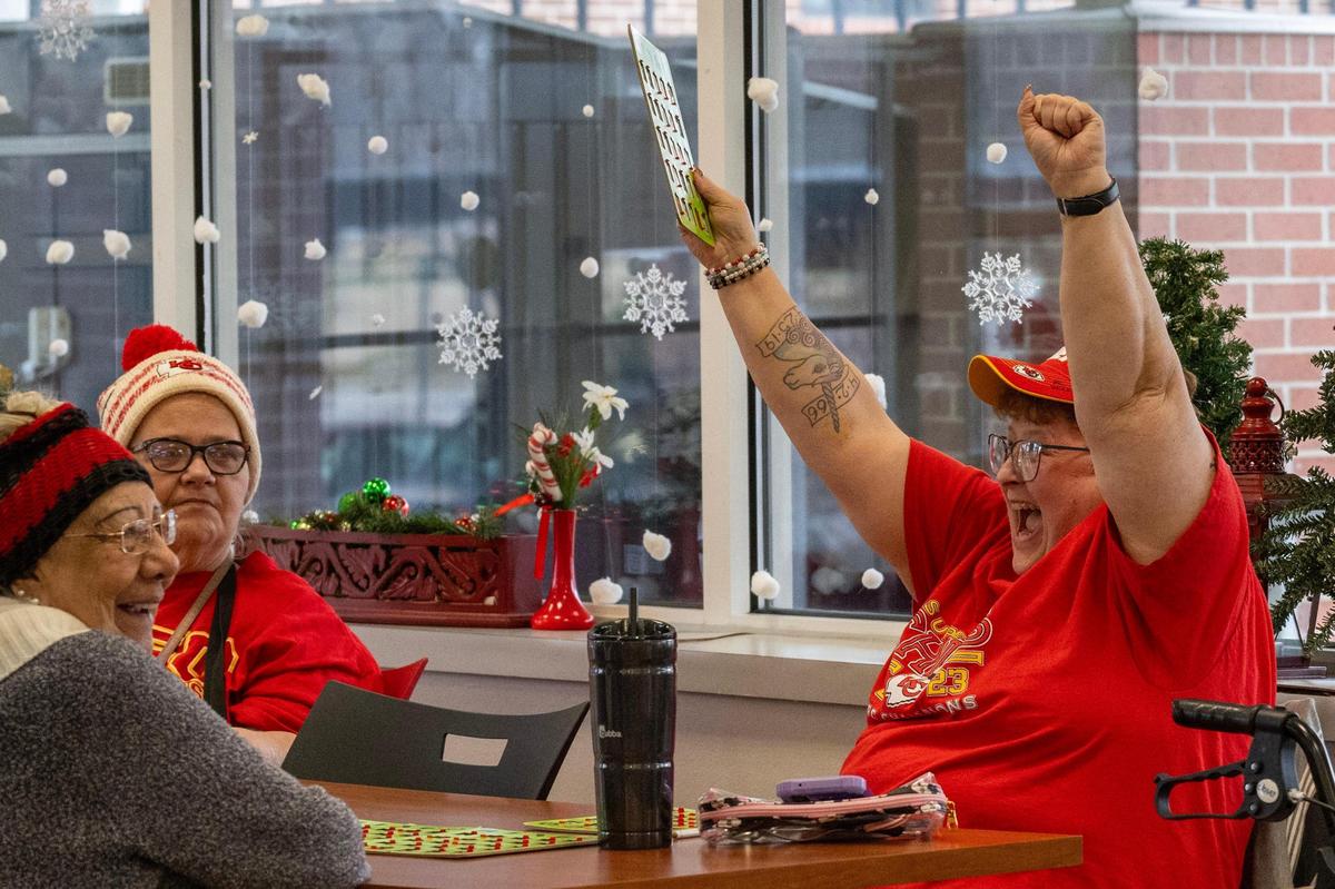 Elizabeth McDaniel raises her arms after she wins at bingo.