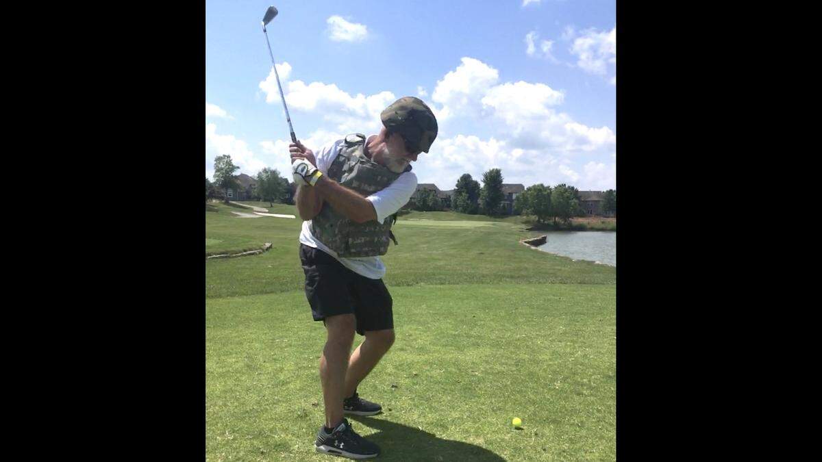 Wearing a helmet and flak jacket, Kenny Kopta of Olathe competes in the Combat Golf Tournament at Falcon Lakes Golf Club in Basehor.