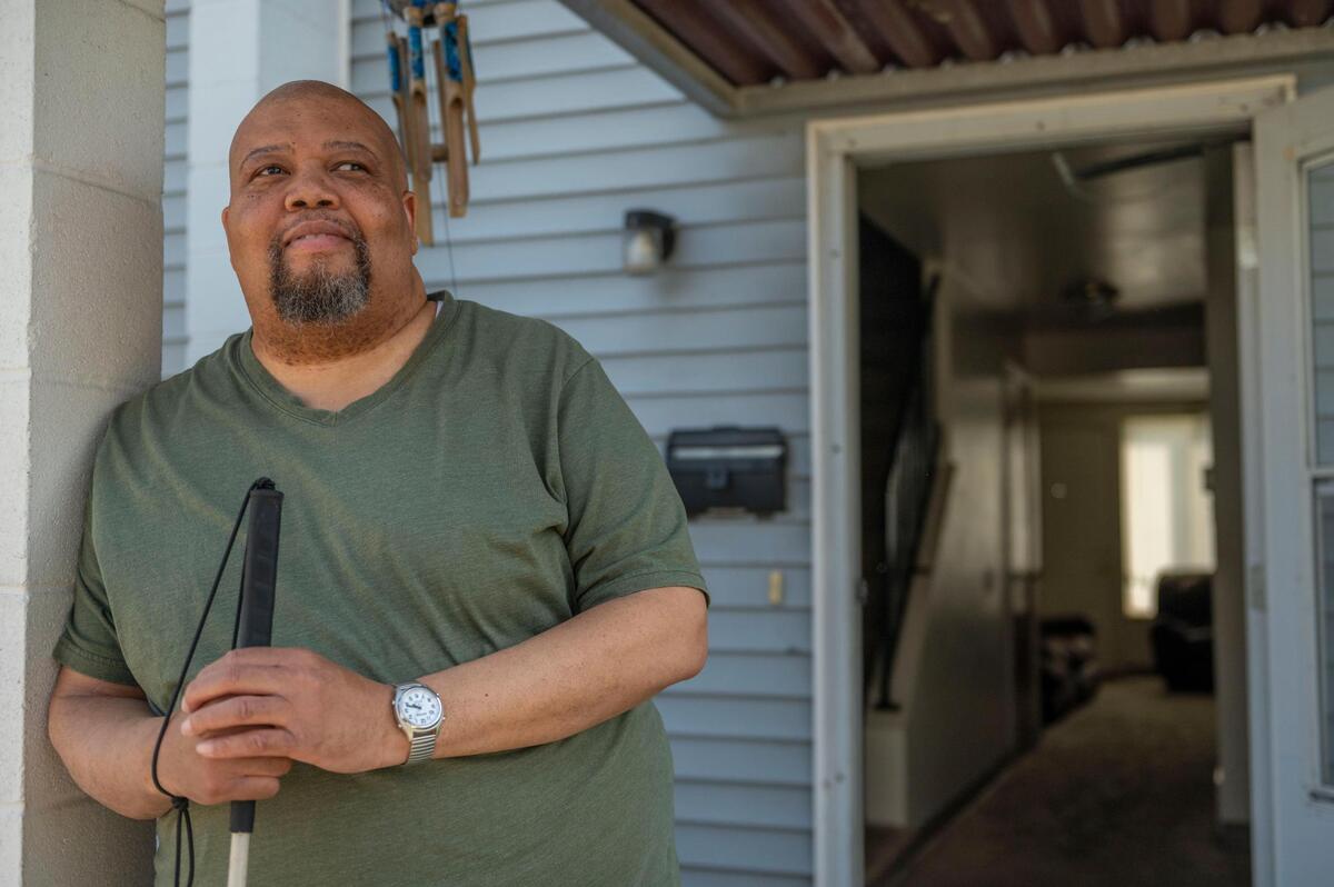 Darrin Sherman stands outside his front door at his townhome in Kansas City on Tuesday, April 12, 2022. Sherman, a resident of Parade Park Homes since April 2013, recently moved to south Kansas City after a water leak in his home led to severe damage. He repeatedly called for management to help him but the problem was never fixed, he said.