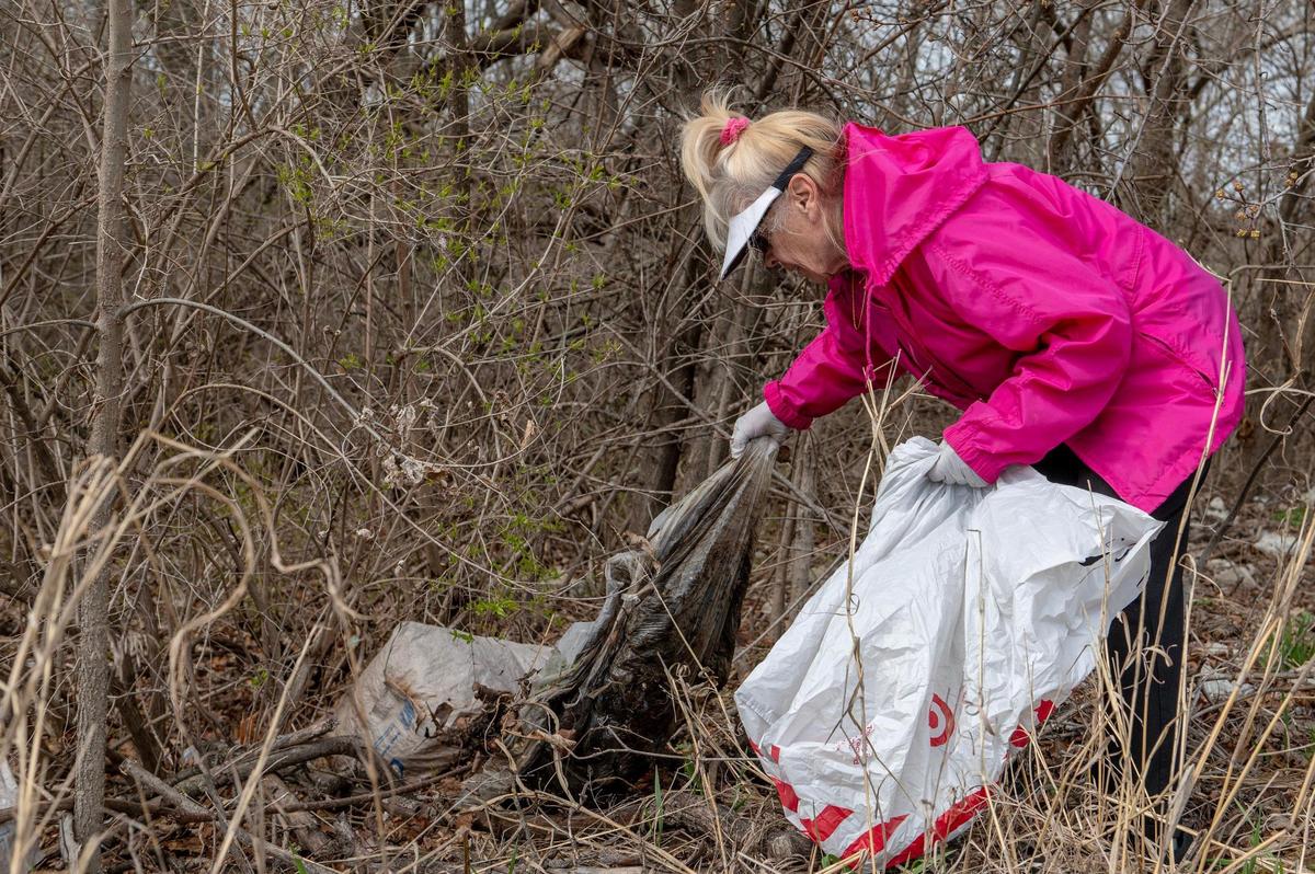 Kathy LeFrensen picks up plastic debris along East Blue Ridge Boulevard on Wednesday, March 15, 2023, in Kansas City.