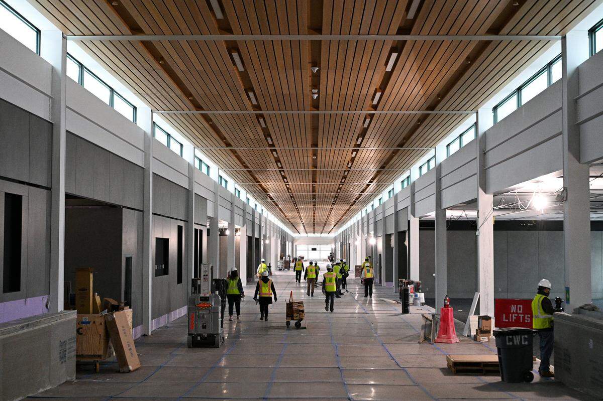The wood ceilings with lighting and terrazzo flooring have been installed at Concourse B of the new single terminal at Kansas City International Airport. For its protection, however, the flooring has been covered. Unlike Concourse A, gates run along both sides of Concourse B. The Kansas City Aviation Department gave a tour of the new terminal building to show its progress Thursday, March 24, 2022.