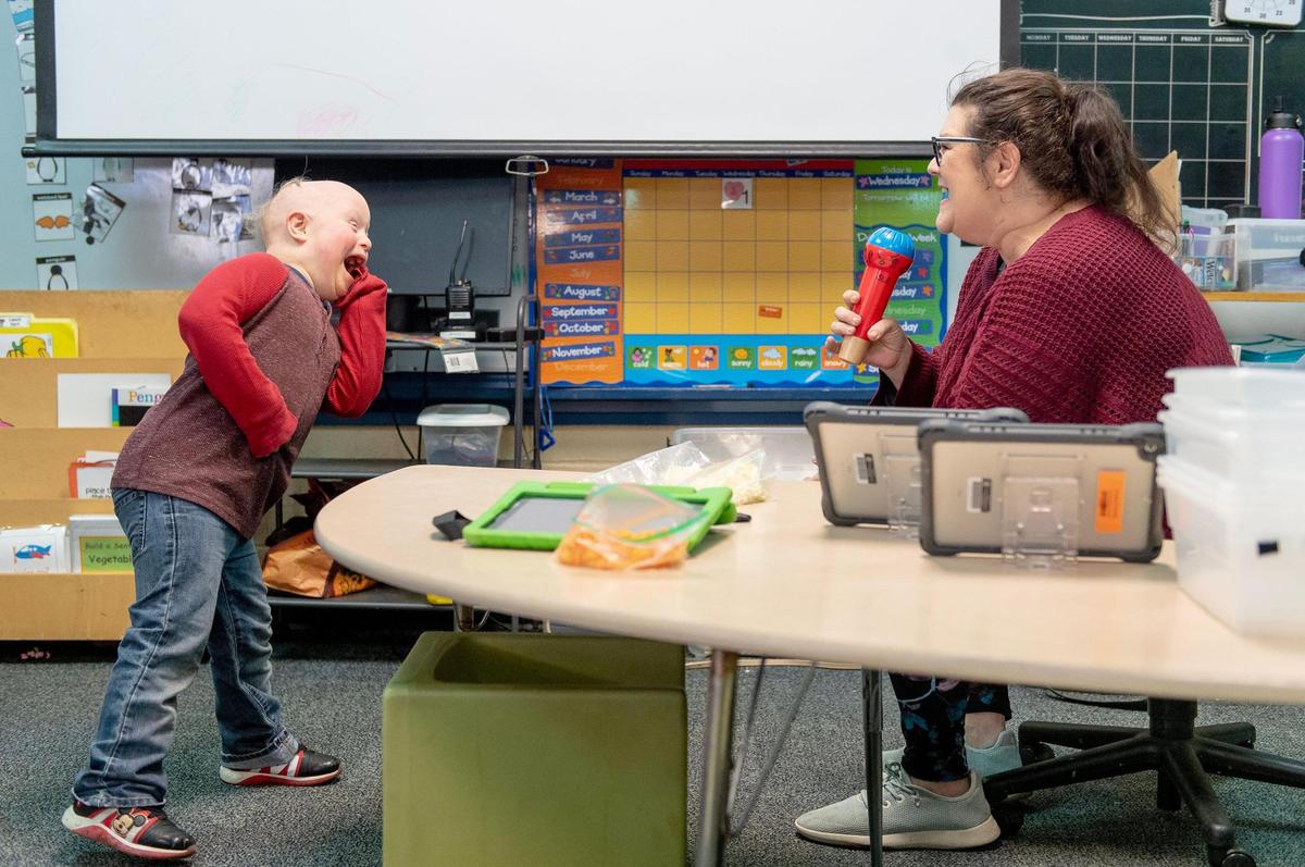 Alexa Scarlett, a special education teacher in the Shawnee Mission school district, sings a song from the Disney movie Moana with student Crosby Orlando. Parents say special ed classes are understaffed and under-resourced.